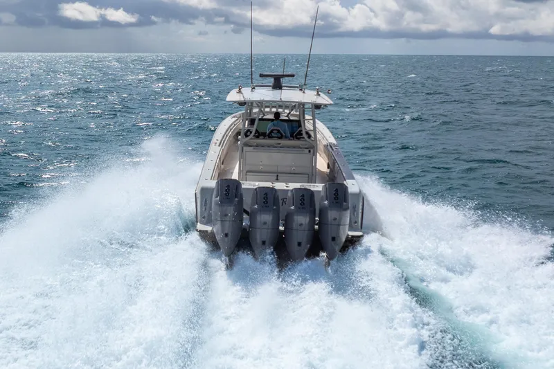 Four Reels Yacht Photos Pics 2021 Contender 44 CB boat speeding on ocean with powerful engines.