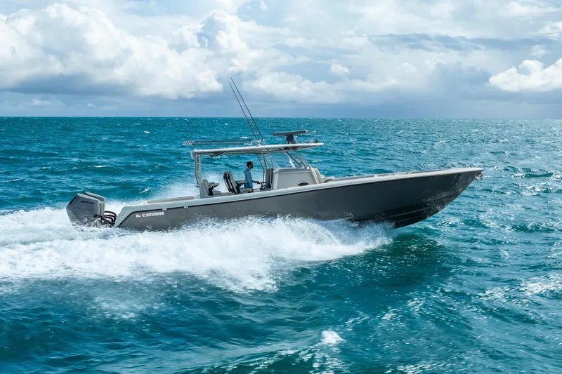 Four Reels Yacht Photos Pics 2021 Contender 44 CB boat cruising on open ocean under cloudy sky.