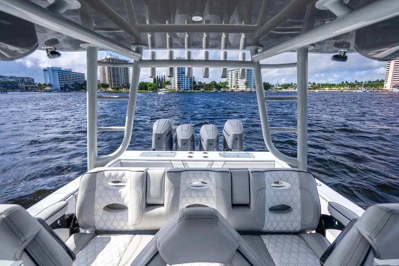 Four Reels Yacht Photos Pics 2021 Contender 44 CB boat interior with luxurious seating and powerful engines on a scenic waterway.