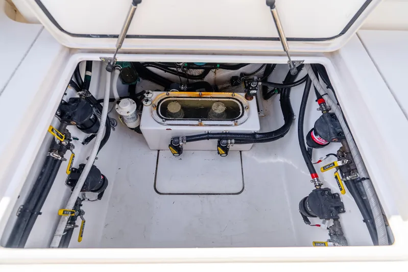Four Reels Yacht Photos Pics 2021 Contender 44 CB boat compartment with pumps and hoses, showcasing internal components.