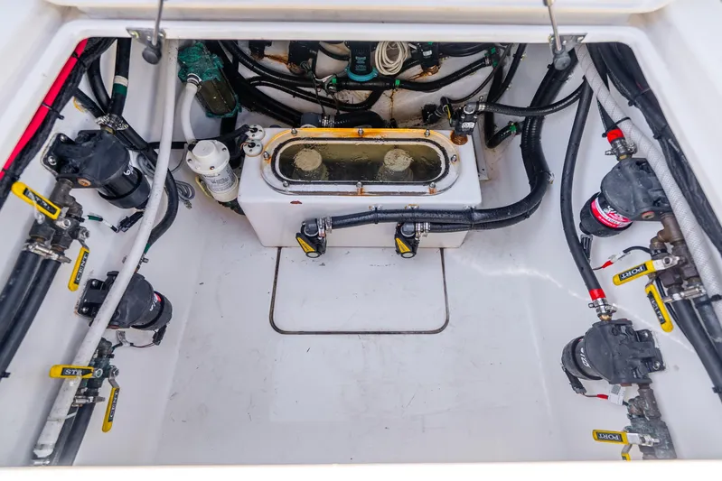 Four Reels Yacht Photos Pics 2021 Contender 44 CB boat engine compartment with pumps and hoses.