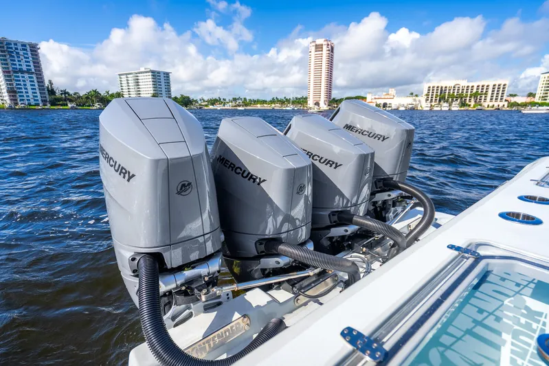 Four Reels Yacht Photos Pics Four Mercury outboard engines on a 2021 Contender 44 CB boat, with cityscape in background.