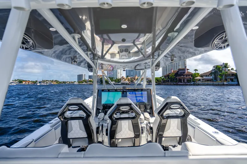 Four Reels Yacht Photos Pics 2021 Contender 44 CB boat interior with three seats, advanced navigation, and waterfront view.