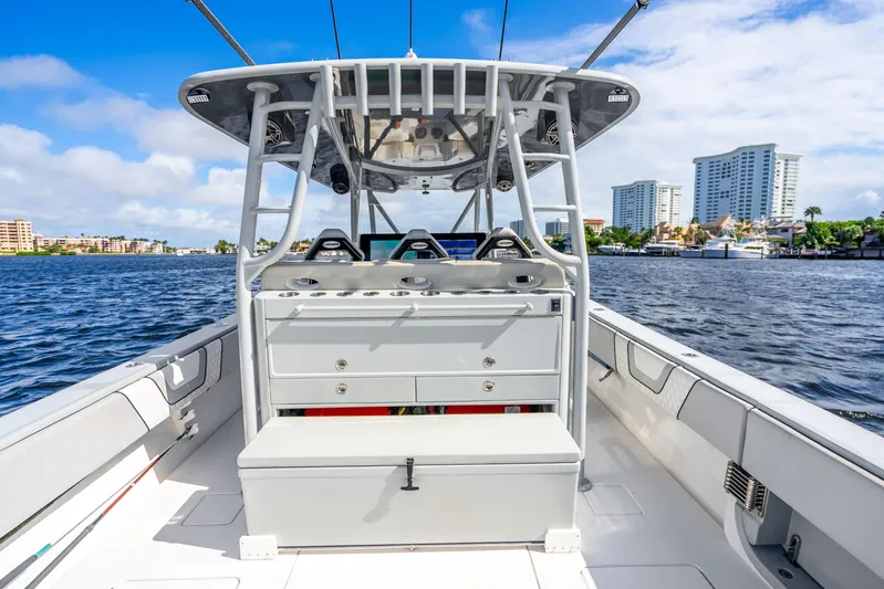 Four Reels Yacht Photos Pics 2021 Contender 44 CB boat on water, cityscape in background, clear sky.