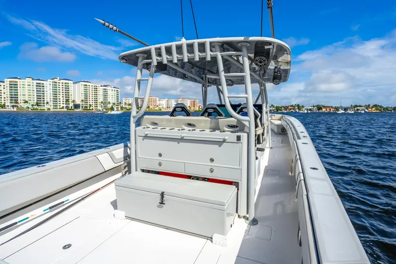 Four Reels Yacht Photos Pics 2021 Contender 44 CB boat on water, modern design, cityscape background, clear blue sky.
