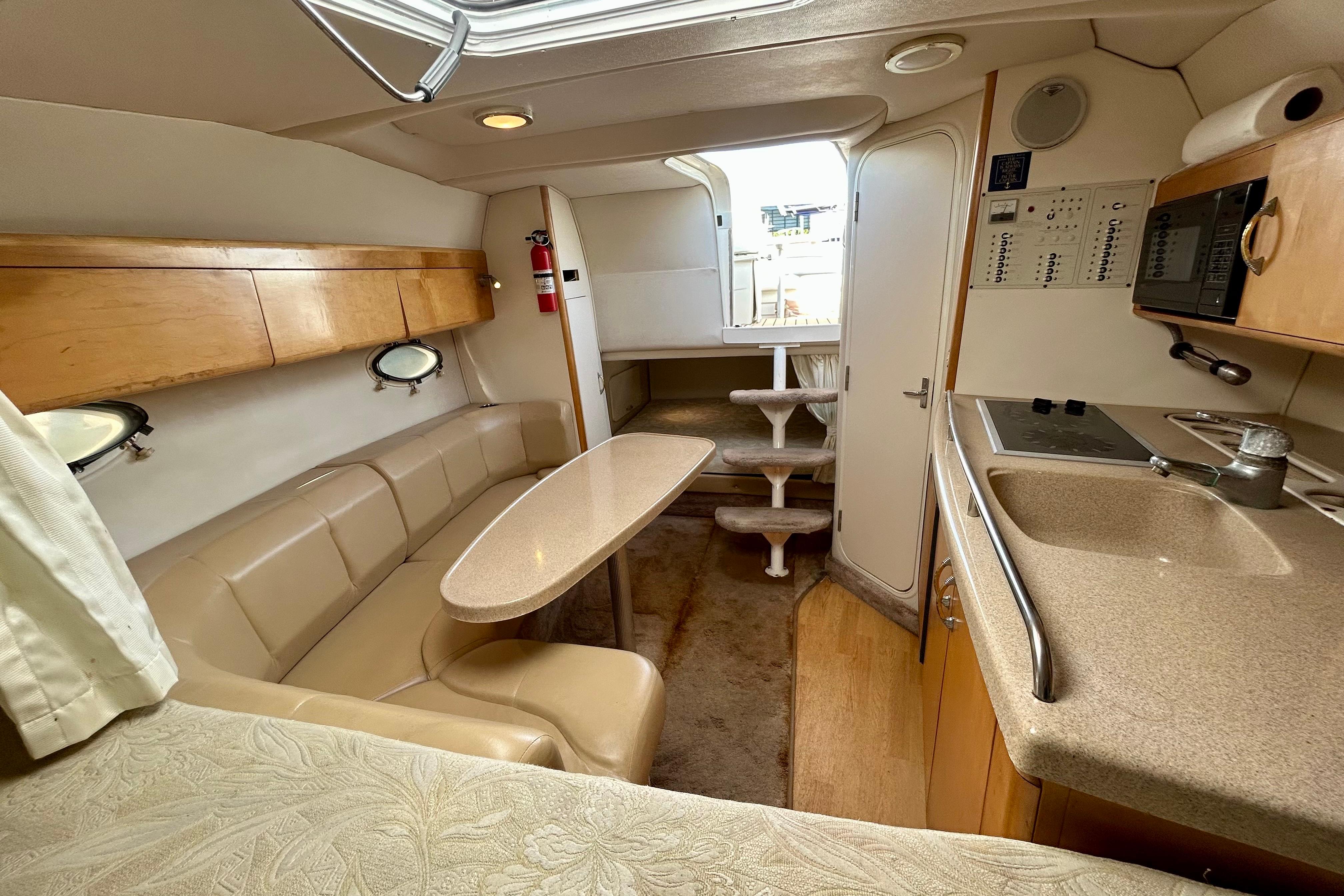 Interior of 2000 Larson 290 Cabrio boat with kitchenette and seating area.