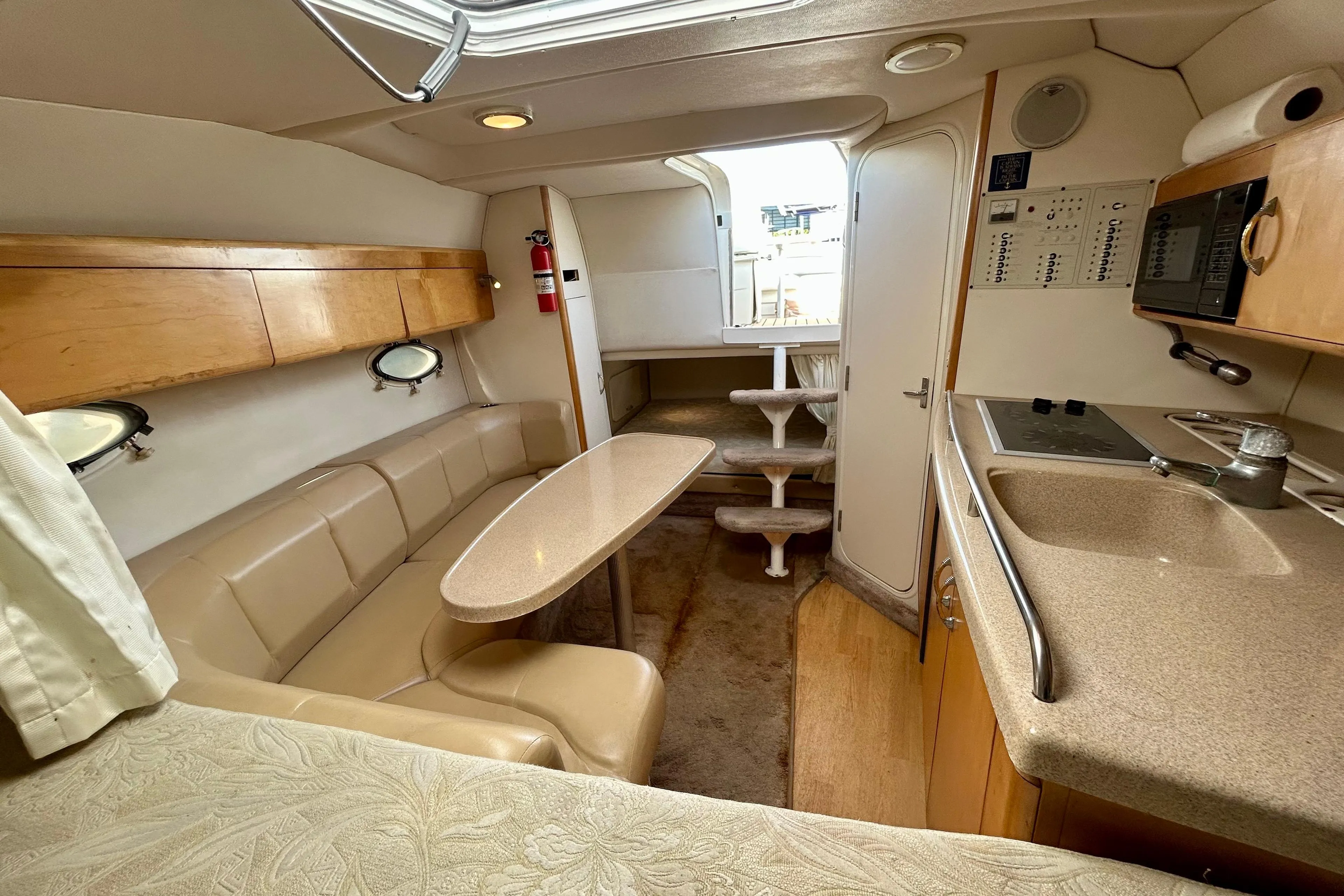 Interior of 2000 Larson 290 Cabrio boat with kitchenette and seating area.