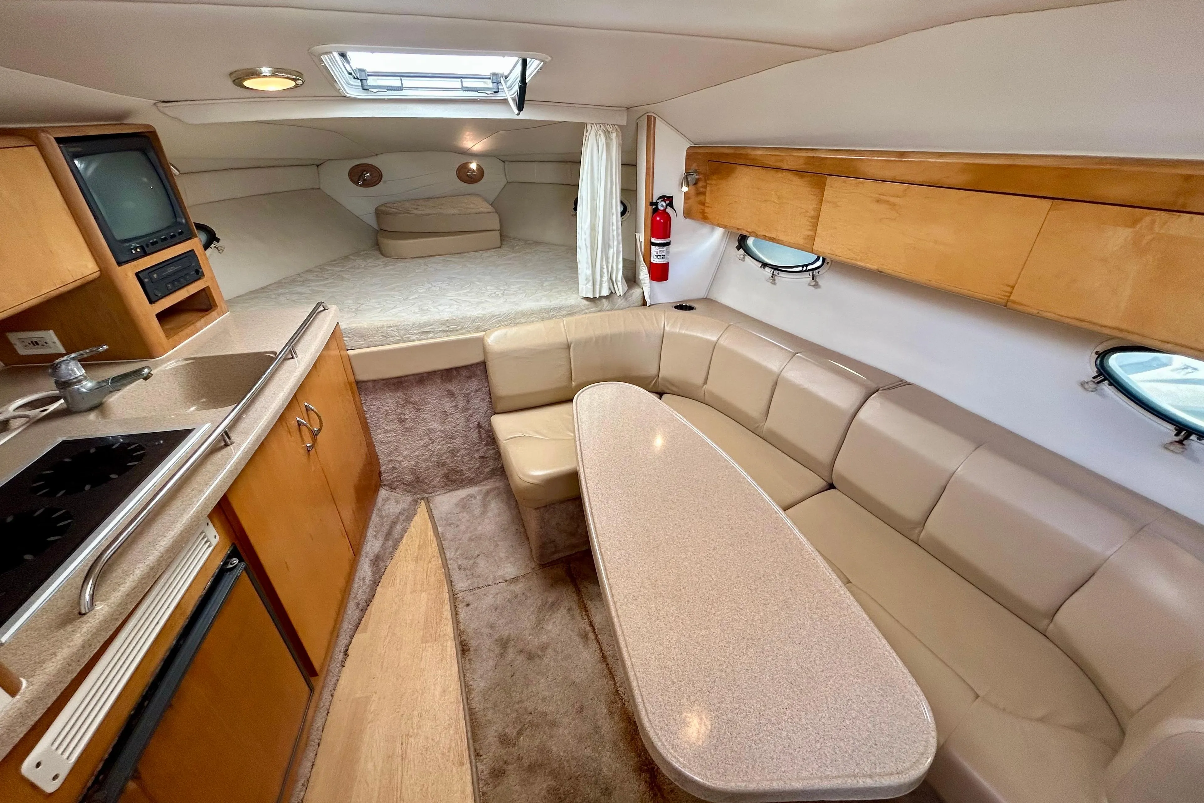 Interior of 2000 Larson 290 Cabrio boat with kitchenette, seating, and sleeping area.