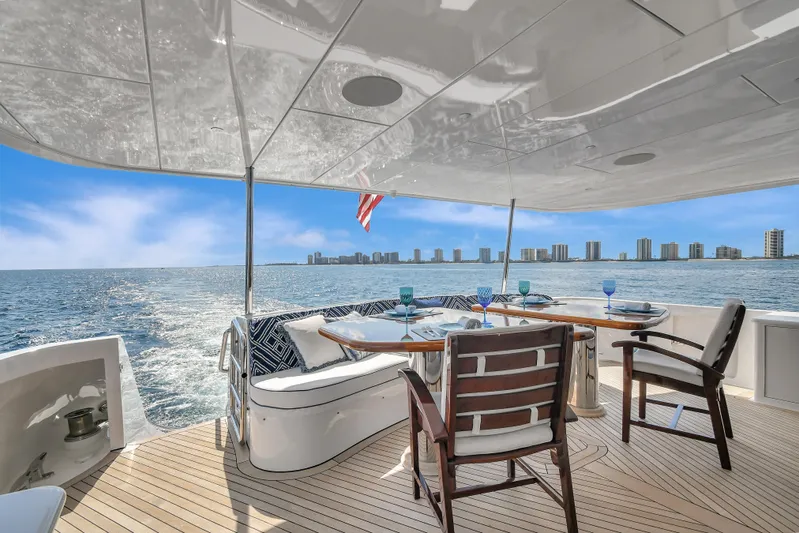 Danielle Yacht Photos Pics Outdoor dining area on 2005 Hatteras 100 Motor Yacht with ocean view and city skyline.