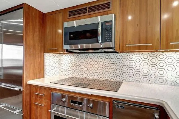 Danielle Yacht Photos Pics Modern kitchen in 2005 Hatteras 100 Motor Yacht with sleek appliances and hexagonal tile backsplash.