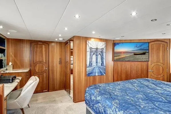 Danielle Yacht Photos Pics Luxurious bedroom interior of 2005 Hatteras 100 Motor Yacht with elegant wood paneling.
