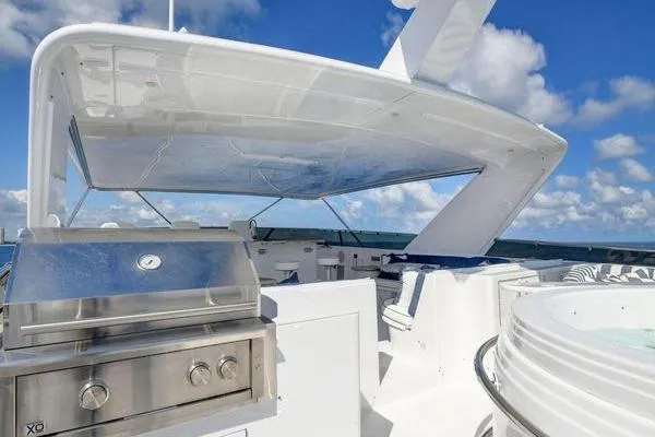 Danielle Yacht Photos Pics Luxury 2005 Hatteras 100 Motor Yacht deck with grill and jacuzzi under blue sky.