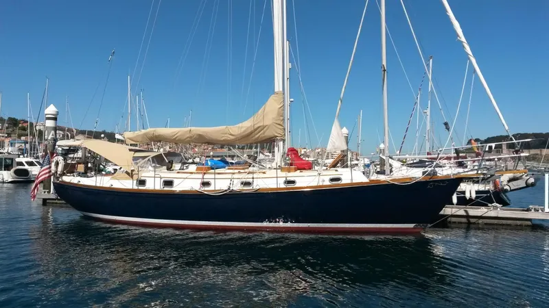 Glory Yacht Photos Pics Sailboat Shannon 43 Cutter 2001 docked in marina, blue hull, beige sail cover.