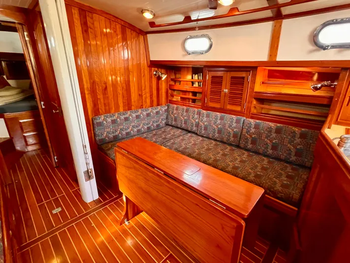 Glory Yacht Photos Pics Interior of 2001 Shannon 43 Cutter sailboat with wooden paneling and cozy seating area.
