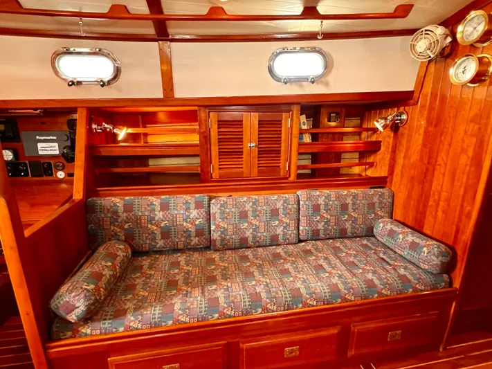 Glory Yacht Photos Pics Cozy interior of 2001 Shannon 43 Cutter with patterned seating and wooden cabinetry.