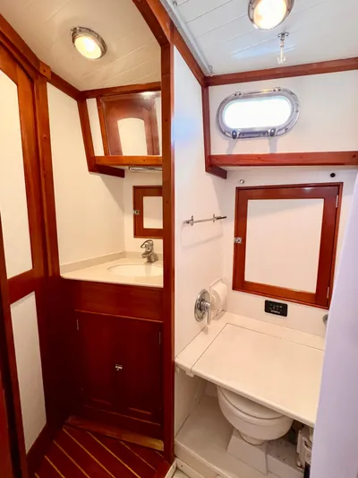 Glory Yacht Photos Pics 2001 Shannon 43 Cutter bathroom with wood accents, sink, and porthole window.
