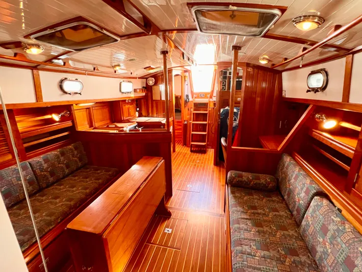 Glory Yacht Photos Pics Luxurious interior of 2001 Shannon 43 Cutter sailboat with wooden furnishings and cozy seating.