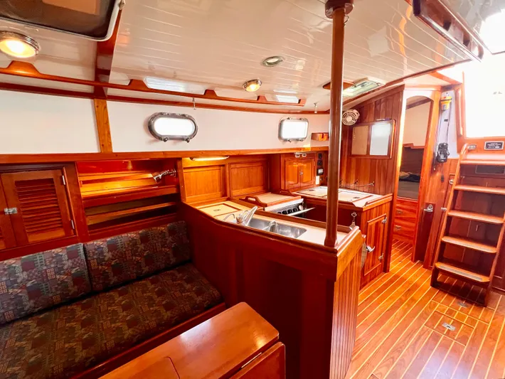 Glory Yacht Photos Pics Interior of 2001 Shannon 43 Cutter sailboat with wooden cabinetry and cozy seating area.