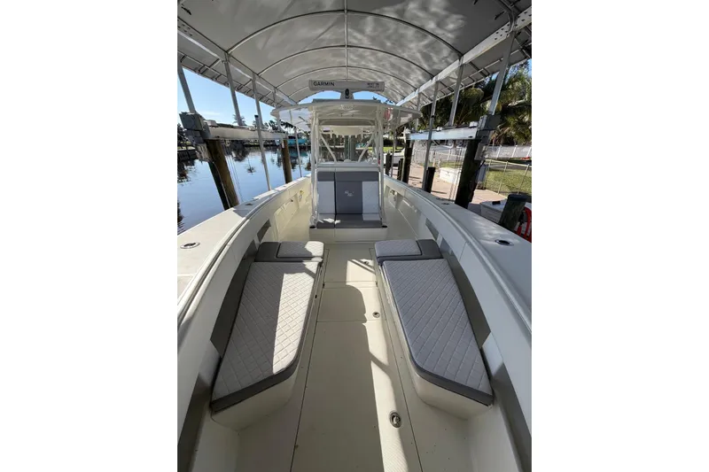  Yacht Photos Pics 2018 SeaVee 390Z boat interior with cushioned seating and canopy, docked by the water.