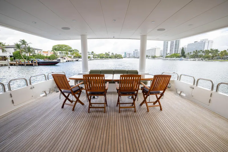 Ocean 1 Yacht Photos Pics Luxury yacht deck with wooden chairs, table, and waterfront view on 2008 Hargrave Sky Lounge.
