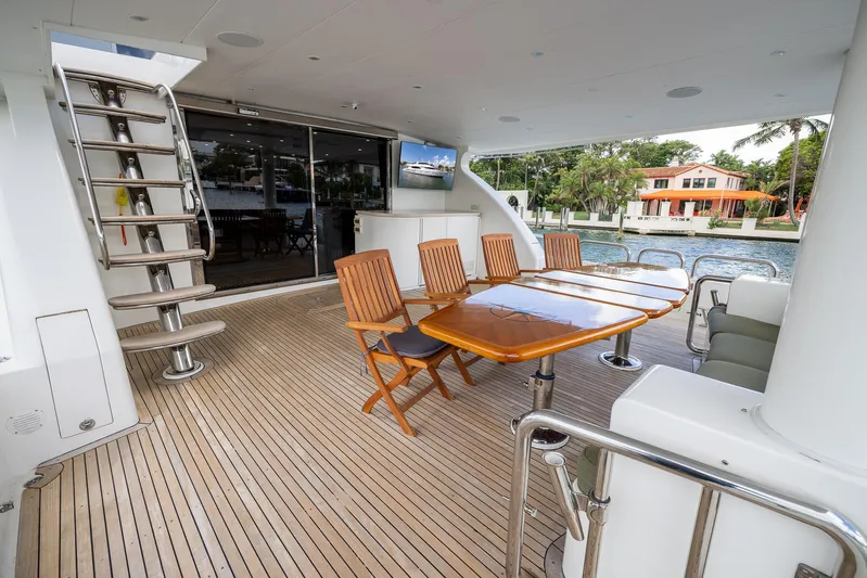 Ocean 1 Yacht Photos Pics Luxurious 2008 Hargrave Sky Lounge yacht deck with wooden table and chairs.