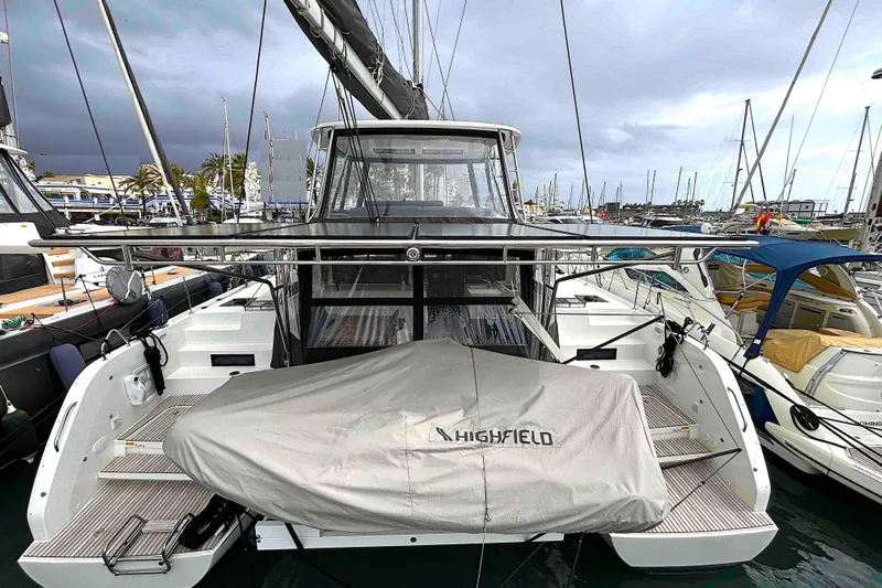  Yacht Photos Pics 2023 Lagoon 46 catamaran docked at marina, featuring covered Highfield tender.