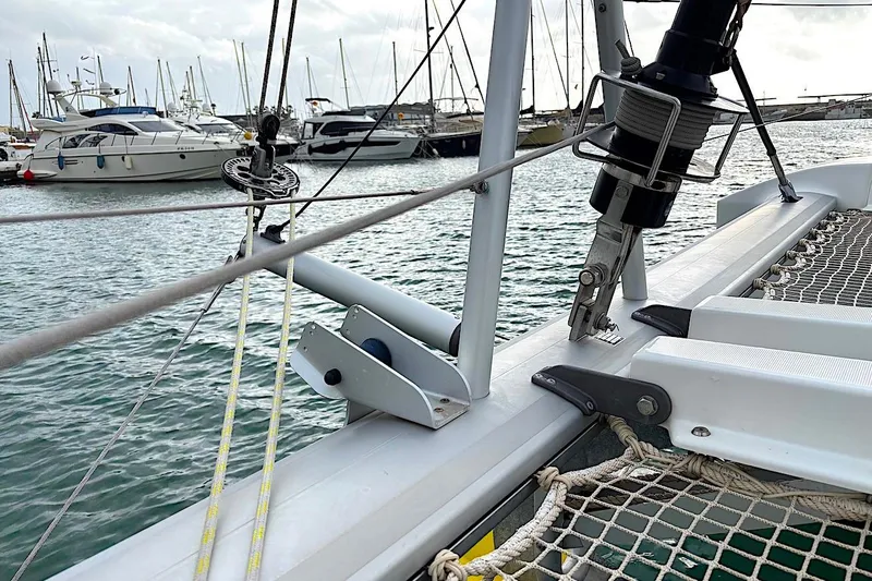  Yacht Photos Pics 2023 Lagoon 46 catamaran detail with marina and yachts in the background.