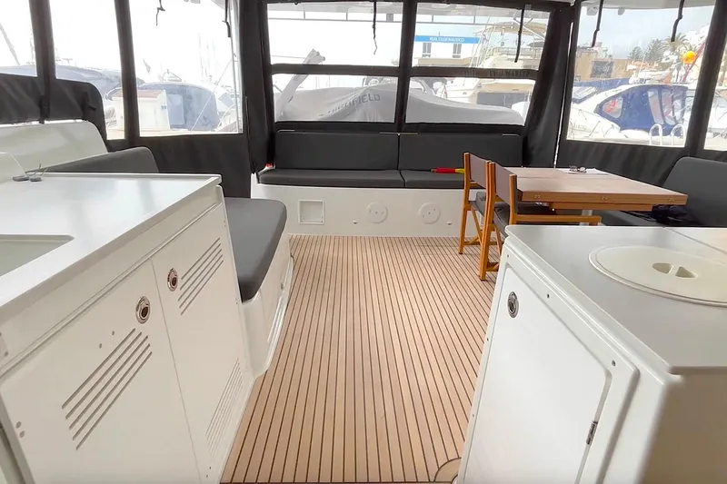  Yacht Photos Pics Interior of 2023 Lagoon 46 yacht with seating, table, and cabinetry.