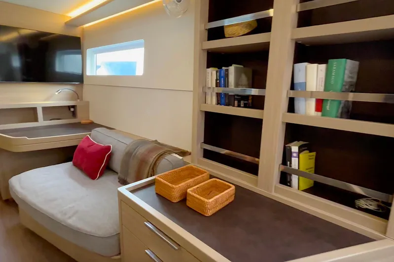  Yacht Photos Pics Luxurious 2023 Lagoon 46 yacht interior with cozy seating, bookshelves, and modern decor.