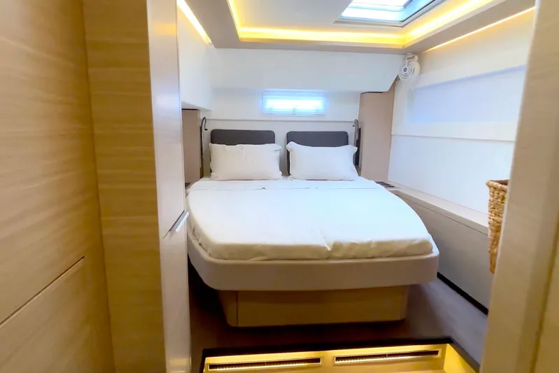  Yacht Photos Pics Luxurious bedroom interior of 2023 Lagoon 46 yacht with modern lighting and cozy bedding.