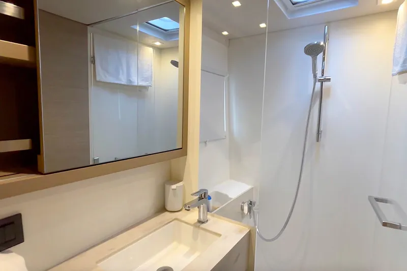  Yacht Photos Pics Modern bathroom in 2023 Lagoon 46 yacht with sleek fixtures and spacious shower.