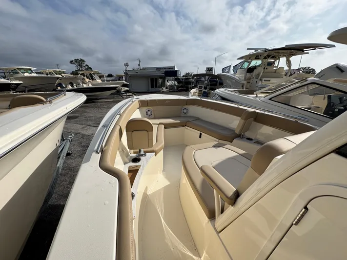  Yacht Photos Pics 2025 Scout 240 XSF boat with beige interior, docked among other boats.