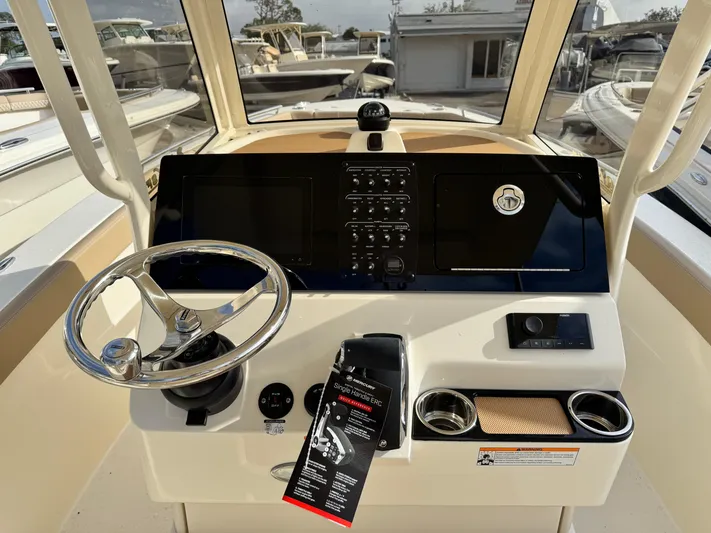  Yacht Photos Pics 2025 Scout 240 XSF boat dashboard with steering wheel and control panel.