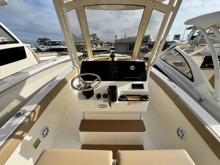  Yacht Photos Pics 2025 Scout 240 XSF boat interior with steering console and seating.