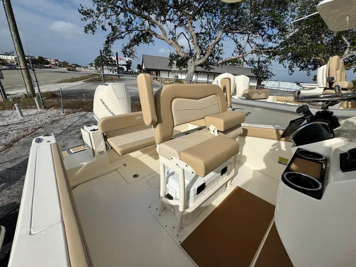  Yacht Photos Pics 2025 Scout 240 XSF boat interior with beige seating and console, parked outdoors.