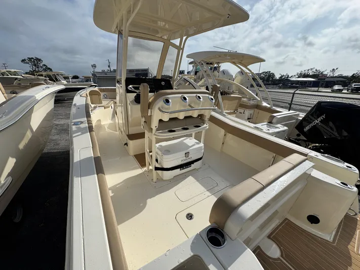  Yacht Photos Pics 2025 Scout 240 XSF boat interior with seating and console, parked outdoors.