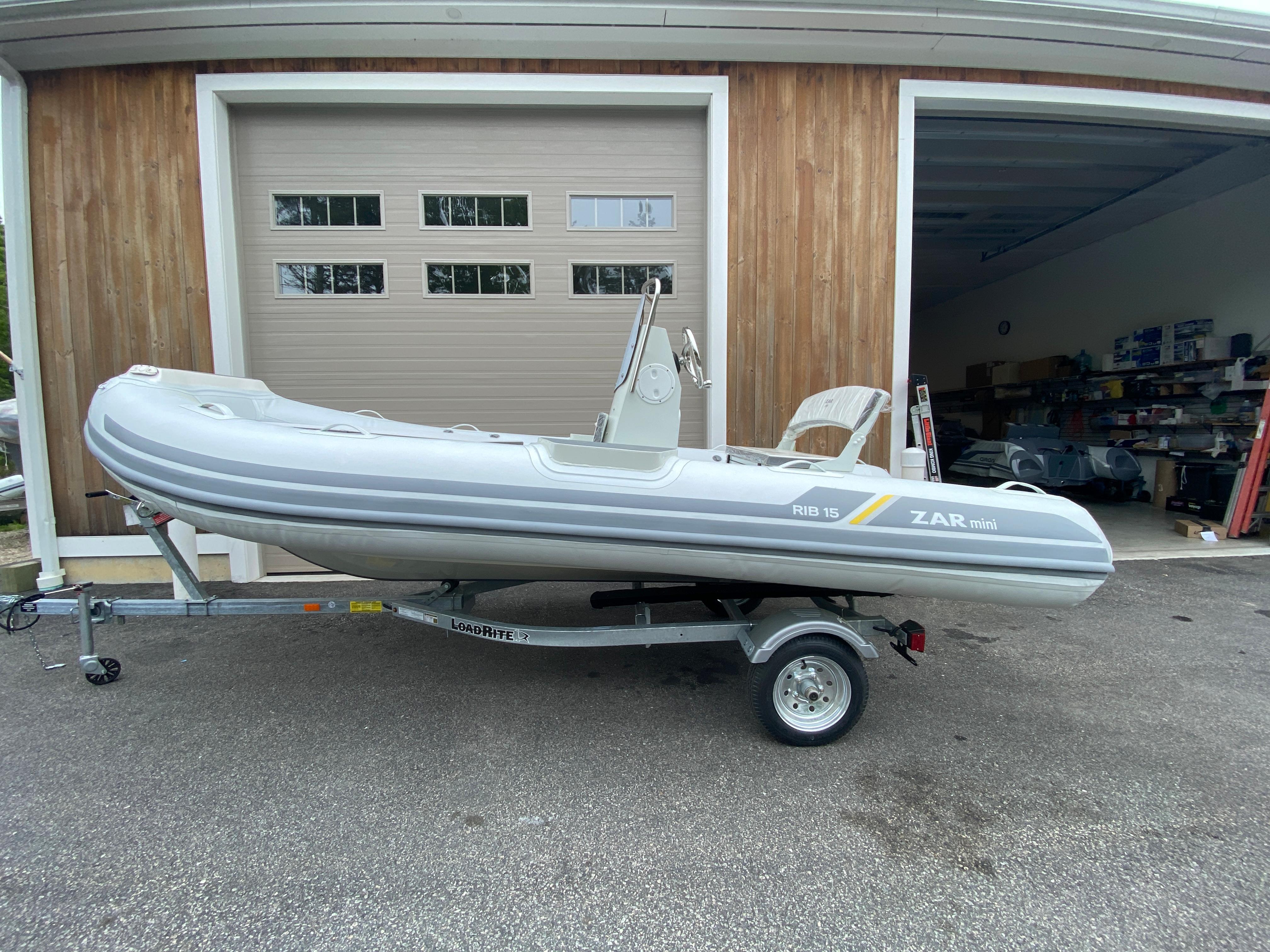 2022 ZAR Mini RIB 15 HDL Tender 60 Hp on trailer outside garage.