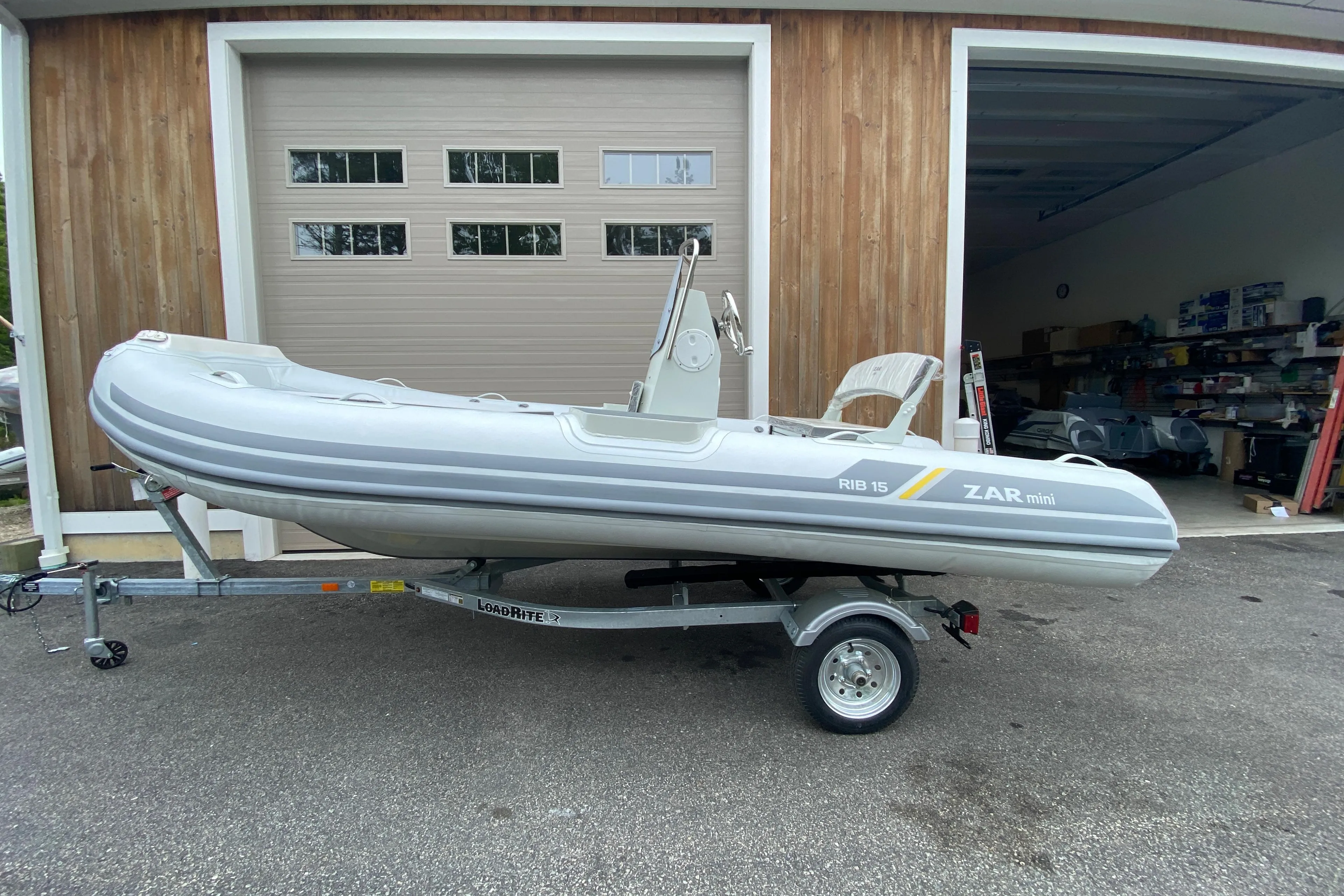 2022 ZAR Mini RIB 15 HDL Tender 60 Hp on trailer outside garage.