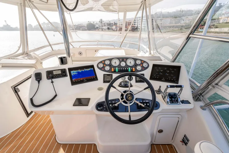 Roll The Dice Yacht Photos Pics Cockpit of 2005 Riviera 47 Convertible yacht with steering wheel and navigation controls.