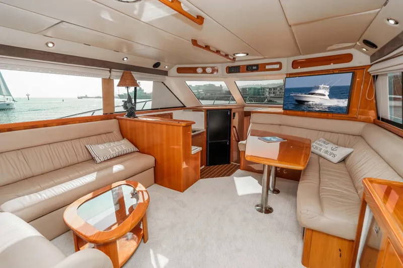 Roll The Dice Yacht Photos Pics Luxurious interior of 2005 Riviera 47 Convertible yacht with plush seating and ocean view.