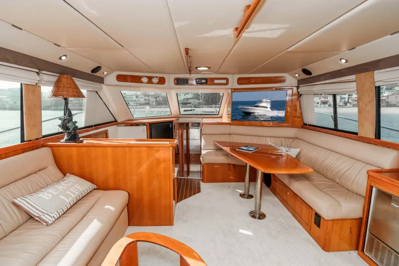 Roll The Dice Yacht Photos Pics Luxurious interior of 2005 Riviera 47 Convertible yacht with elegant seating and wooden finishes.