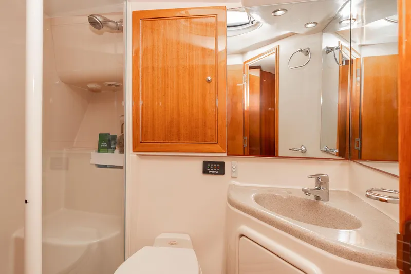 Roll The Dice Yacht Photos Pics Luxurious bathroom interior of 2005 Riviera 47 Convertible yacht with wooden cabinetry.