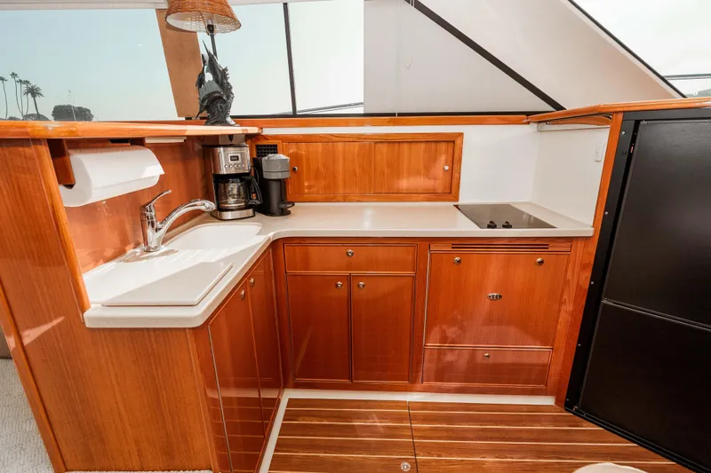 Roll The Dice Yacht Photos Pics Luxurious 2005 Riviera 47 Convertible yacht kitchen with wood cabinetry and modern appliances.
