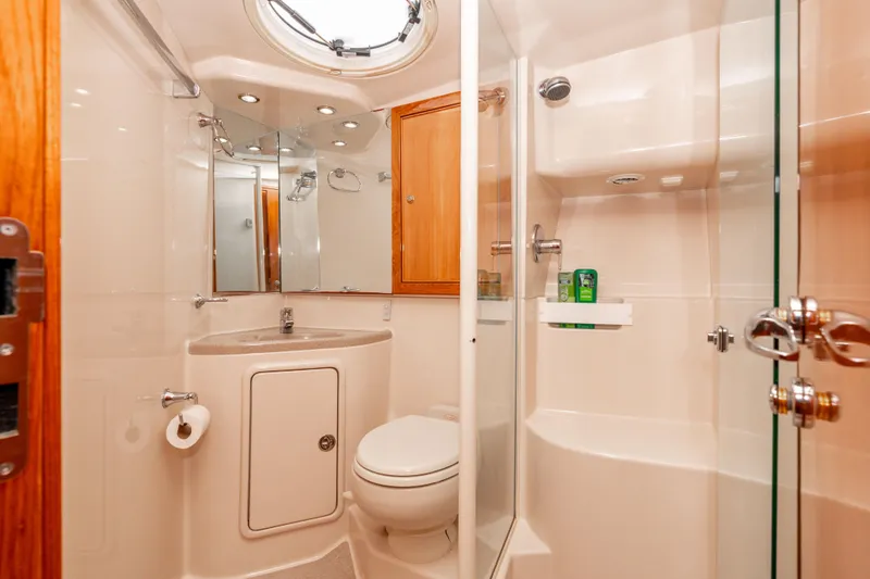 Roll The Dice Yacht Photos Pics Luxurious bathroom in 2005 Riviera 47 Convertible yacht with modern fixtures and glass shower.