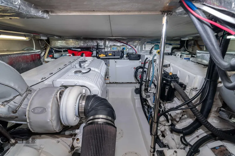 Roll The Dice Yacht Photos Pics Engine room of a 2005 Riviera 47 Convertible yacht, showcasing mechanical components.