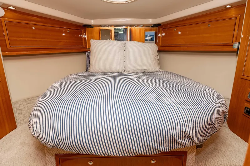 Roll The Dice Yacht Photos Pics Luxurious bedroom interior of 2005 Riviera 47 Convertible yacht with striped bedding.
