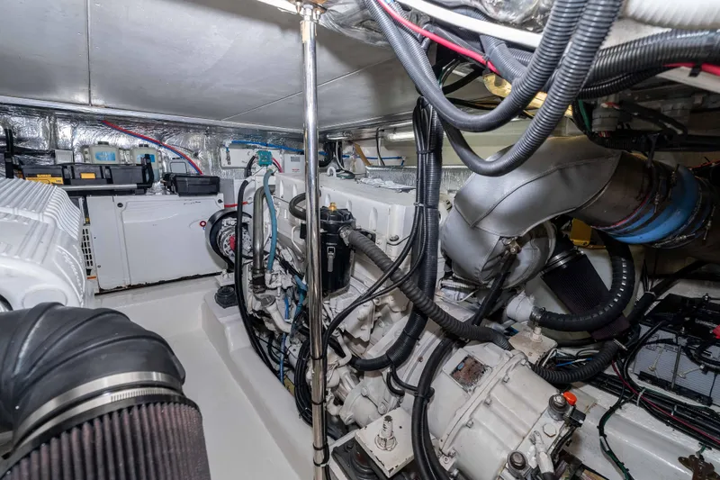 Roll The Dice Yacht Photos Pics Engine room of a 2005 Riviera 47 Convertible yacht, showcasing complex machinery and wiring.