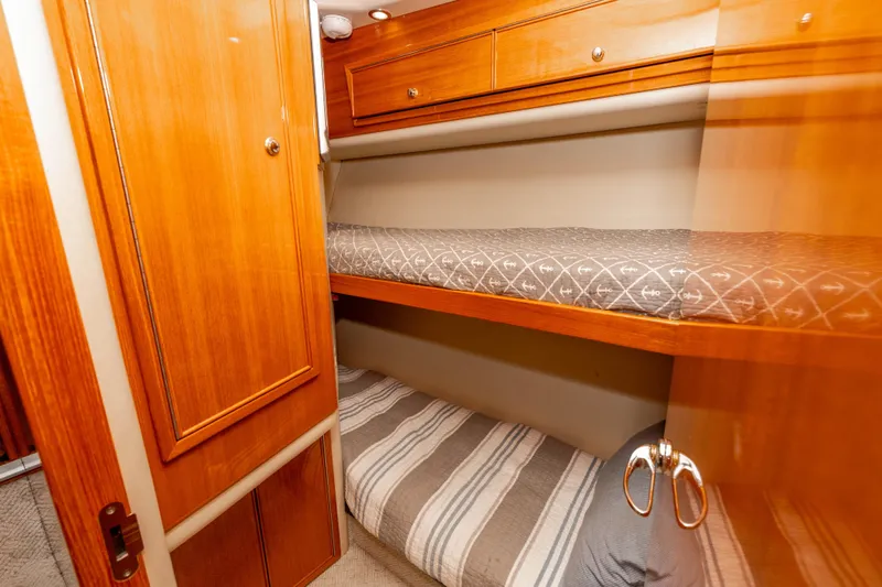 Roll The Dice Yacht Photos Pics 2005 Riviera 47 Convertible yacht interior with wooden bunk beds and storage.