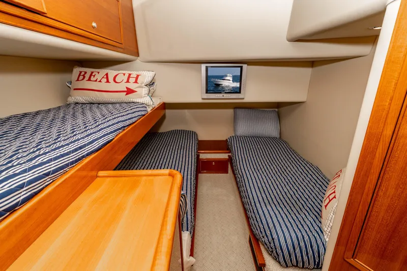 Roll The Dice Yacht Photos Pics 2005 Riviera 47 Convertible cabin with striped bedding and nautical decor.