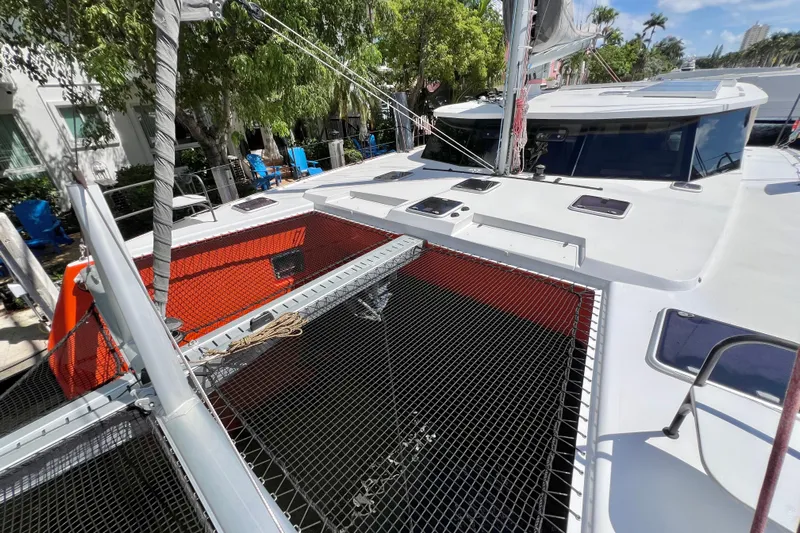 Ke'ala Yacht Photos Pics 2021 Balance 482 catamaran with netting and sails, docked near trees and buildings.